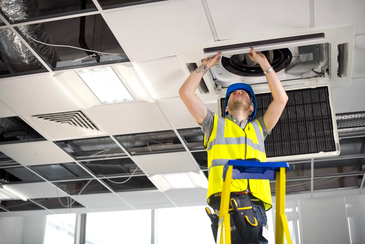 Technician performing air condition repair in Minnesota home
